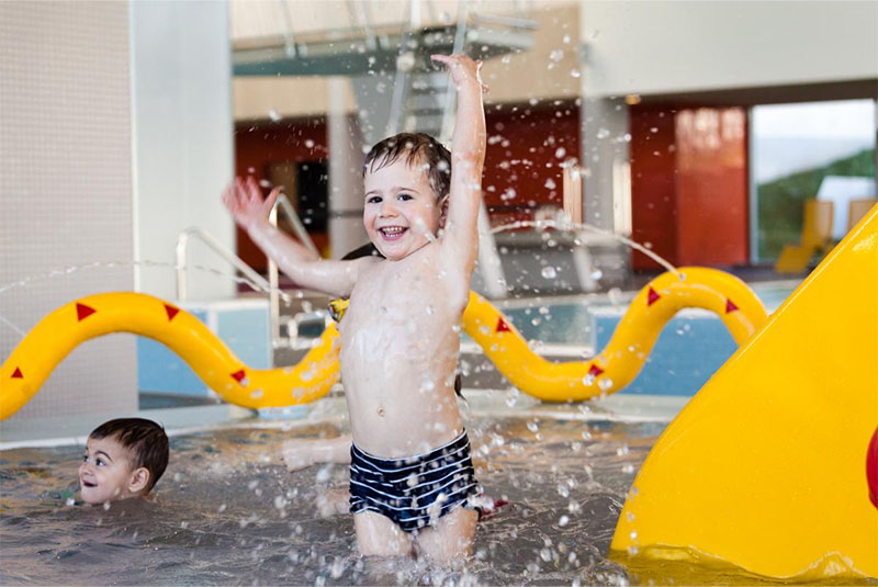 Spaß und Freude eines kleinen Jungen, der fröhlich im Wasser planscht in unserem Familienbad im Stadtbad Gotha