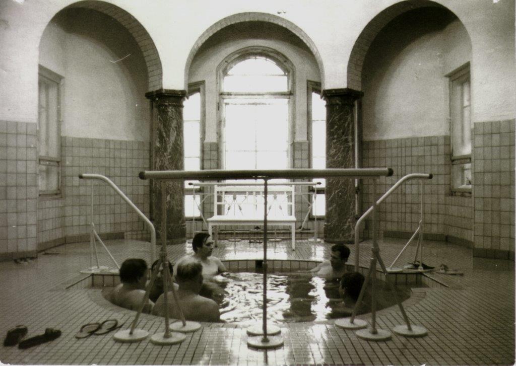 Sicht auf badende Männer im Duschraum Stadtbad Gotha um 1980.